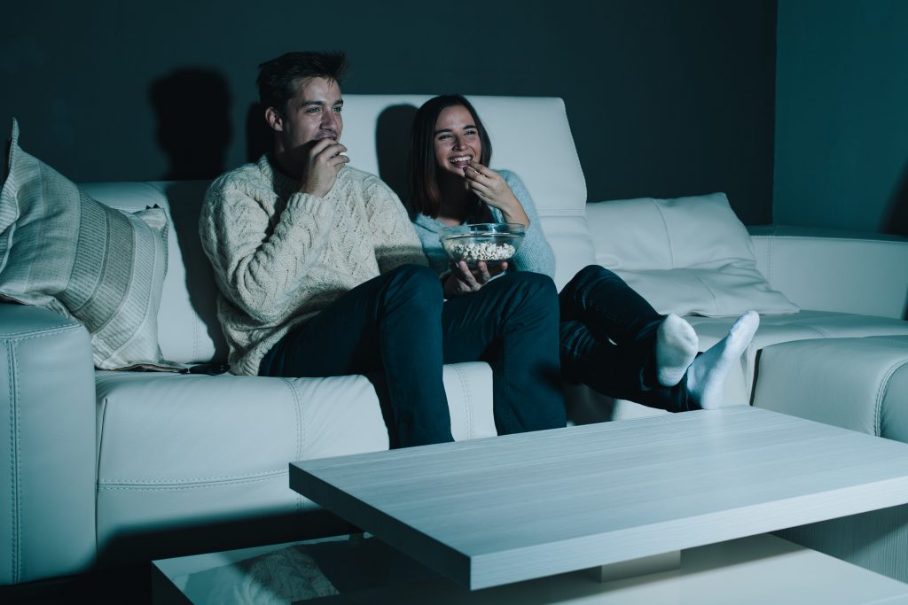 Couple enjoying watching a movie at home laughing on the couch CrawKan Telephone Cooperative