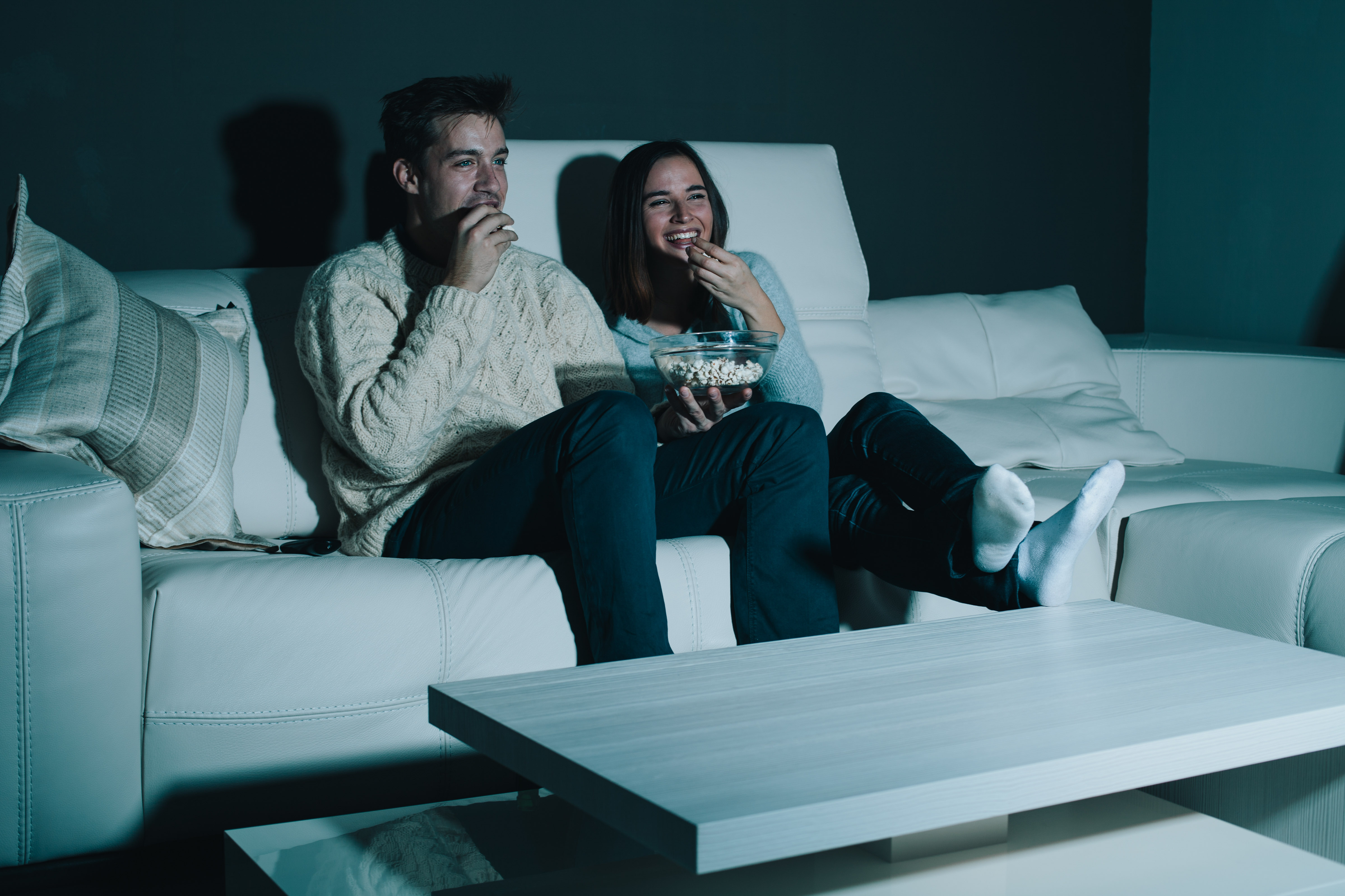 Watching performance. Парень и девушка на диване. Мужчина у телевизора. Пара на диване перед телевизором. Парень и девушка сидят на диване.
